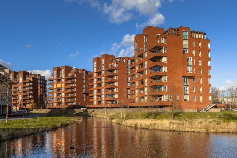 red brick mid-rise apartment buildings by the river bank